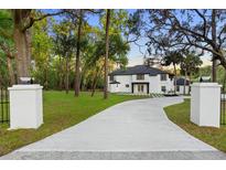 Stunning two-story home with a modern design, featuring a long driveway and lush greenery at 305 Sweetwater Club Cir, Longwood, FL 32779