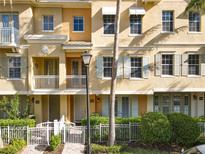 Charming townhome with white picket fence, front balcony and neutral stucco color at 728 Greybull Run, Lake Mary, FL 32746