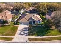 A beautiful single-story home with a clay tile roof, a well-manicured lawn, and a long driveway in a suburban neighborhood at 11314 Ledgement Ln, Windermere, FL 34786
