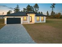 Charming single-story home with a modern design, dark gray accents, and a well-manicured lawn at 16697 Sw 23Rd Avenue Rd, Ocala, FL 34473