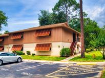 Two-story condo unit featuring unique window shutters and an assigned parking space with marked fire lane at 190 Hickory Woods Ct # 1B, Deltona, FL 32725