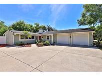 Charming single-story home boasts a spacious driveway, attached garage, and vibrant landscaping at 426 S Lakemont Ave, Winter Park, FL 32792
