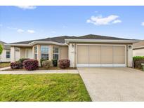 Charming single-story home featuring a well-maintained lawn and a two-car garage at 8602 Se 133Rd Ln, Summerfield, FL 34491