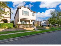 Inviting two-story home featuring a well-maintained lawn and beautifully landscaped surroundings at 9330 Meadow Hunt Way, Winter Garden, FL 34787
