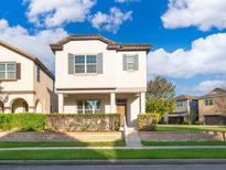 Charming two-story home with a manicured front yard and a welcoming front porch at 9330 Meadow Hunt Way, Winter Garden, FL 34787