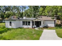 Charming white home featuring a well-manicured lawn and contrasting black trim accents at 239 S Lake Cortez Dr, Apopka, FL 32703