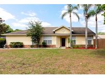 Charming single-story home with a well-manicured lawn and beautiful palm trees at 321 Moffat Loop, Oviedo, FL 32765