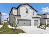 New construction home with a two car garage and a professionally landscaped yard at 854 Poppy Ln, Dundee, FL 33838