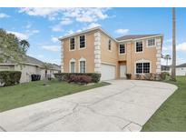 Charming two-story home featuring beige stucco, a well-manicured lawn, and a spacious driveway at 112 Ivy Brook Ct, Davenport, FL 33897