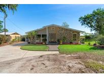 Charming single-story home featuring stone accents, a well-manicured lawn, and a welcoming entrance at 3655 E Osceola Rd, Geneva, FL 32732