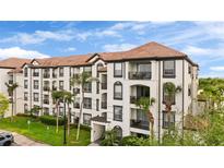 Beautiful condo building with a red tile roof and multiple balconies surrounded by green landscaping and palm trees at 4114 Breakview Dr # 11002, Orlando, FL 32819