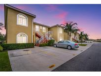 Condo building with well-kept landscaping, red stair accents, and ample parking under a beautiful twilight sky at 5201 Lake Marion Golf Resort # 5201, Kissimmee, FL 34759