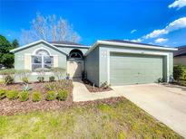 Attractive single-Gathering home featuring a lush lawn, mature landscaping, and an attached two-car garage at 135 Circle Hill Rd, Sanford, FL 32773