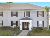 Attractive condo building with gray brick, complemented by black shutters and lush landscaping around the entrance at 302 Lewfield Cir # 302, Winter Park, FL 32792