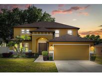 Inviting two-story home featuring a well-manicured lawn and an attached two-car garage at 10820 Wyandotte Dr, Clermont, FL 34711