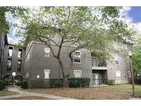 Attractive multi-Gathering building with neutral paint, trimmed windows, lawn area, and mature shade tree at 1321 Arbor Vista Loop # 325, Lake Mary, FL 32746