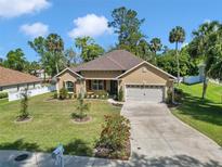 Inviting single-story home featuring lush landscaping, a well-manicured lawn, and a two-car garage, showcasing great curb appeal at 1819 Sw 29Th St, Ocala, FL 34471
