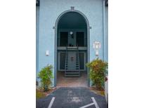 View of a charming building entrance with an arched entryway and stairway leading to the upper level units at 5220 Curry Ford Rd # 303, Orlando, FL 32812