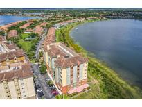 Beautiful aerial view of multi-story condo building next to a lake in a residential community at 8743 S The Esplanade # 18, Orlando, FL 32836