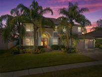 Stunning two-story home with lush landscaping and a three-car garage at sunset at 920 Nola Dr, Ocoee, FL 34761