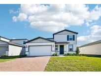 Charming two-story home featuring manicured lawn, brick paved driveway, and attached two car garage at 4532 Windy Oak Way, St Cloud, FL 34772