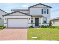 Charming two-story home with a brick driveway, manicured lawn, and a modern color scheme at 4532 Windy Oak Way, St Cloud, FL 34772