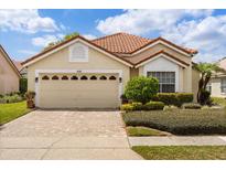 Charming single-story home features a paver driveway, lush landscaping and a neutral-toned garage door at 618 Via Milano, Apopka, FL 32712