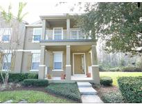 Charming two-story home featuring a porch and second story balcony and beautifully landscaped front yard at 10852 Spider Lily Dr # S, Orlando, FL 32832