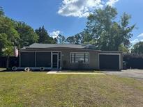 Charming single-story home with a well-maintained lawn and mature trees at 1433 Kingston Ave, Orlando, FL 32807