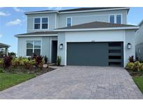 Charming two-story home featuring a modern garage door and beautifully landscaped front yard at 8243 Fenton St, Orlando, FL 32836