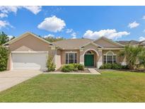 Charming single-story home with a well-manicured lawn, a two-car garage and a welcoming green front door at 9596 Bennington Chase Dr, Orlando, FL 32829