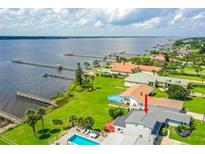 Stunning waterfront property with a pool, lush lawn, and a private dock, offering picturesque views of the water at 3168 S Peninsula Dr, Daytona Beach, FL 32118