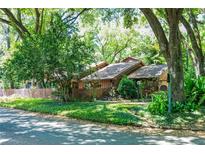 Charming home nestled in a lush, green landscape with mature trees and a well-maintained front yard at 1 W Village Dr, Oviedo, FL 32765