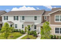Exterior showcasing a neat lawn and neutral-tone facade with stylish architectural detail at 10684 Words Dr, Winter Garden, FL 34787