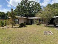 Charming single-story home featuring a well-maintained lawn and mature trees, perfect for curb appeal at 1528 Baltimore Dr, Orlando, FL 32810