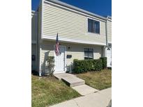 Charming two-story townhome with cream siding, an American flag, and well-maintained landscaping at 247 Debora Ct # 1, Altamonte Springs, FL 32701