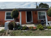 Charming single-story home with an orange exterior and well-maintained landscaping at 330 S Buena Vista Ave, Orlando, FL 32835