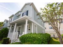 Charming two-story home featuring a welcoming front porch with classic white columns and lush landscaping at 351 Lansbrook Ln, Winter Springs, FL 32708