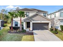 Charming two-story home with a two-car garage, well-manicured lawn, and swaying palm trees at 4569 Cabello Loop, Kissimmee, FL 34746