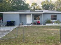 Charming single-story home with solar panels, fenced yard, and well-maintained landscaping at 5117 Barnett Pl, Orlando, FL 32808