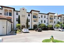Well-maintained condo building featuring stucco siding, a red tile roof, and convenient parking at 5550 E Michigan St # 2114, Orlando, FL 32822