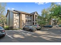 Apartment complex with parking, featuring balconies and a well-maintained exterior, set against a blue sky at 623 Dory Ln # 307, Altamonte Springs, FL 32714