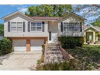 Charming home with two-car garage, well-maintained landscaping, and welcoming entryway stairs at 63 Orange Blossom S Dr, Eustis, FL 32726