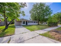 Charming single-story home with a well-manicured lawn and a concrete driveway and walkway at 73 Channing Ave, Orlando, FL 32811
