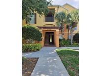 Exterior view of the condo complex with landscaping and walkway at 8775 Sartori St # 302, Orlando, FL 32829