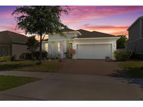 Charming one-story home featuring a two-car garage, brick driveway, and stone facade accents at 944 Flyer St, Orange City, FL 32763