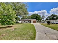 Charming single-story home with a well-maintained lawn, mature trees, and a long driveway at 1179 Shadow Run Dr, Lakeland, FL 33813