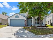 Charming single-story home with a blue front door, a two-car garage, and manicured landscaping at 408 Lexingdale Dr, Orlando, FL 32828