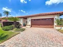 Charming home exterior with a paver driveway, well-manicured landscaping, and a two-car garage at 7808 The Esplanade Ct, Orlando, FL 32836