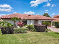 Charming single-story home with a red tile roof and lush, well-maintained landscaping at 7808 The Esplanade Ct, Orlando, FL 32836
